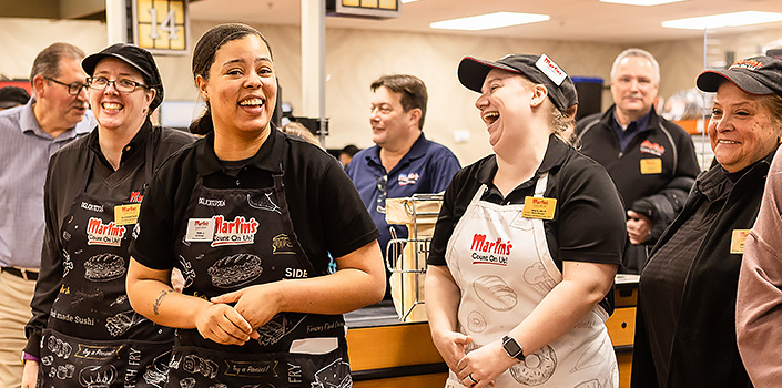 Retail grocery Associates pose in grocery store